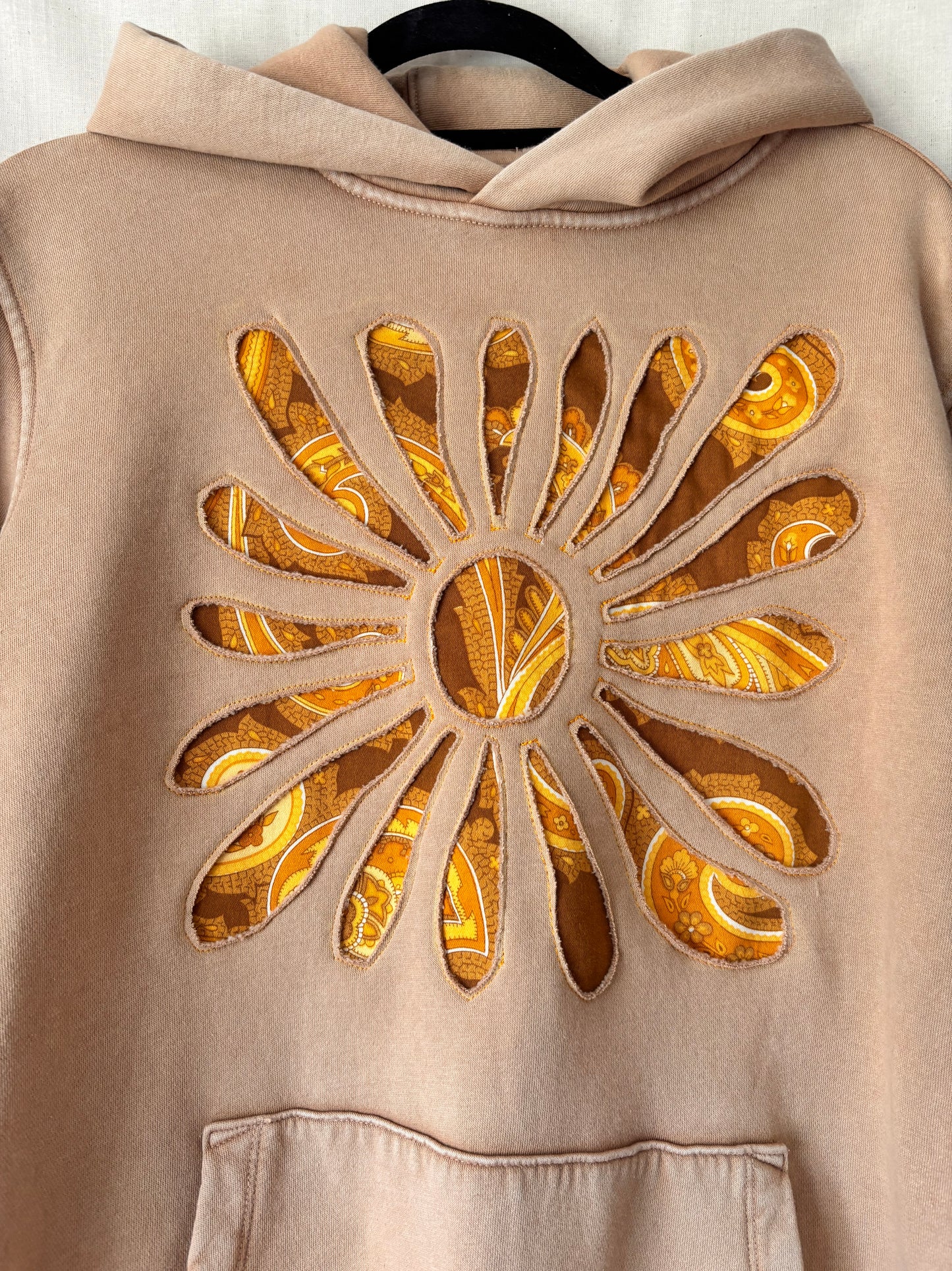 Close up of reverse applique detail on upcycled camel beige Gap hoodie