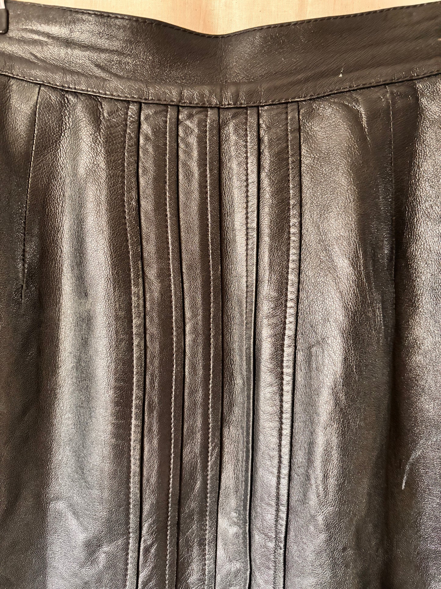 Close-up of pleated black leather skirt