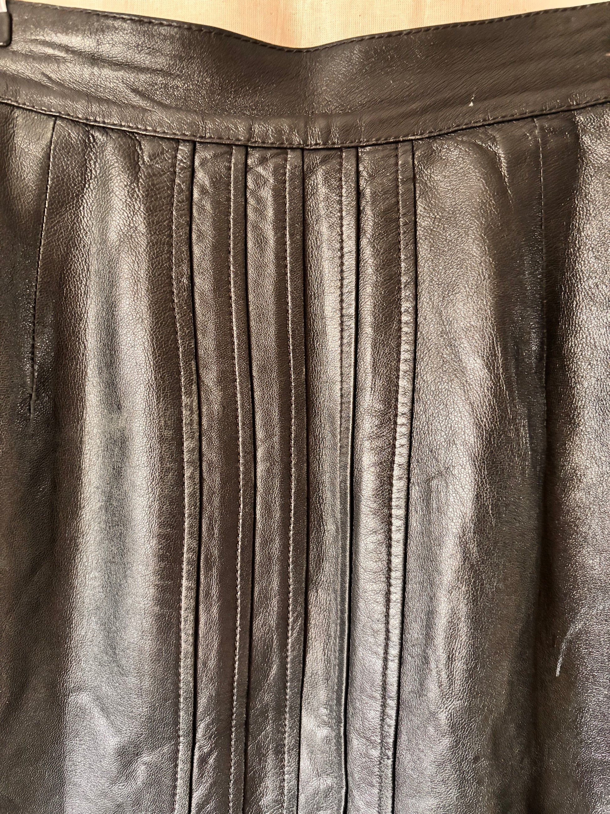 Close-up of pleated black leather skirt