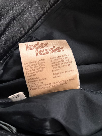 Close-up of a leather tag on a black leather product with visible brand name.