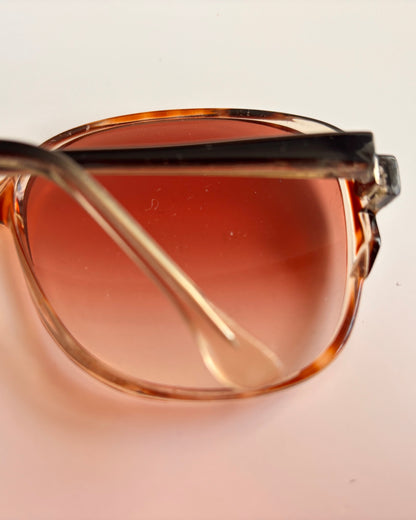 Sunglasses with brown gradient lenses on a light beige background