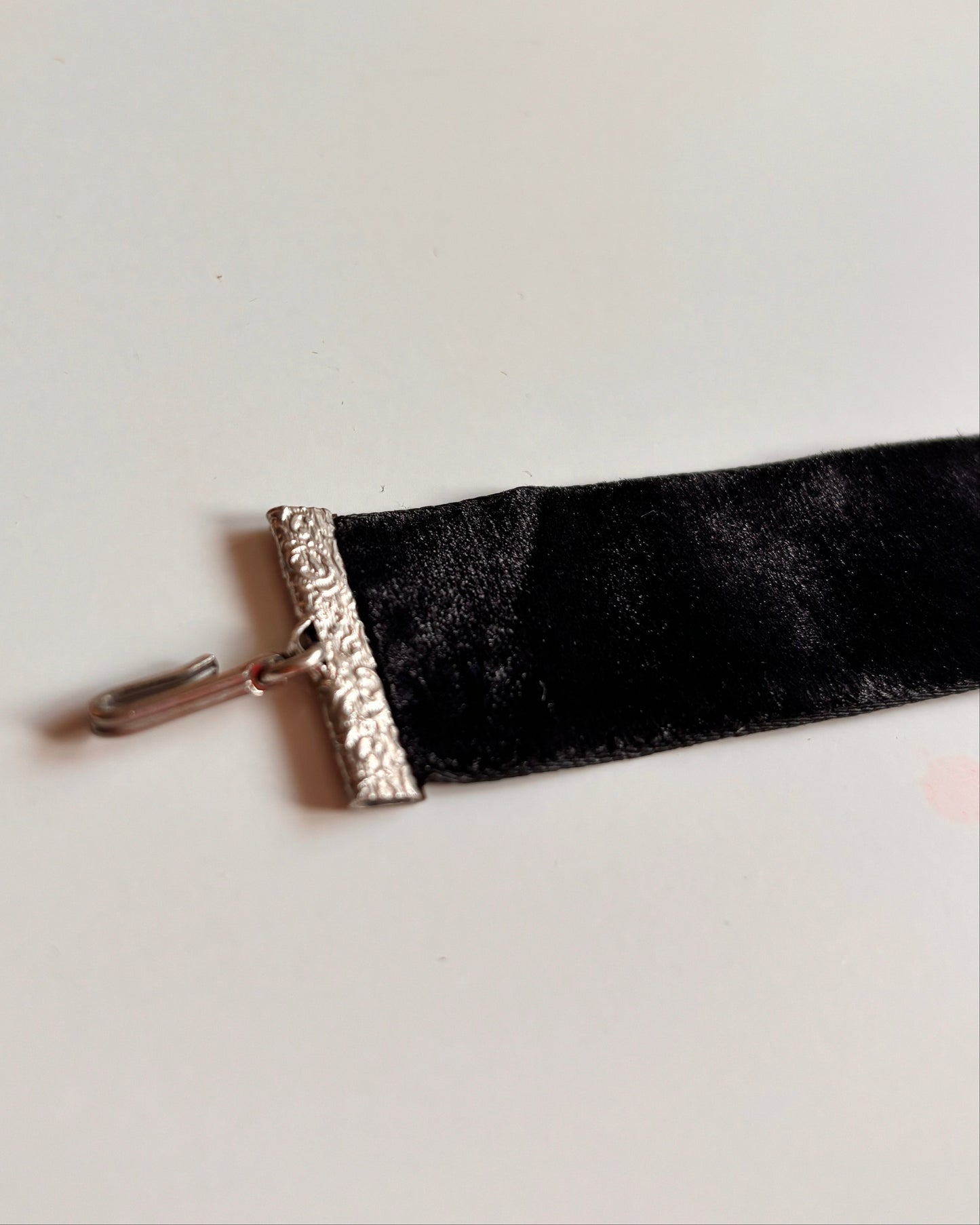 Black velvet ribbon choker with silver trim on a white background